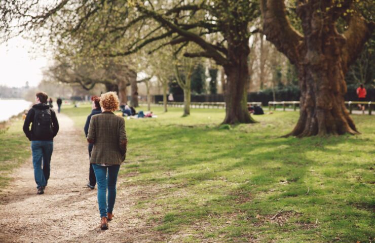 rear-view-people-walking-riverbank