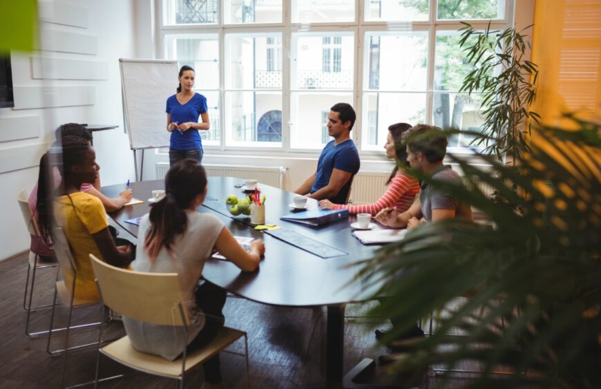 Business executives applauding their colleague after presentation